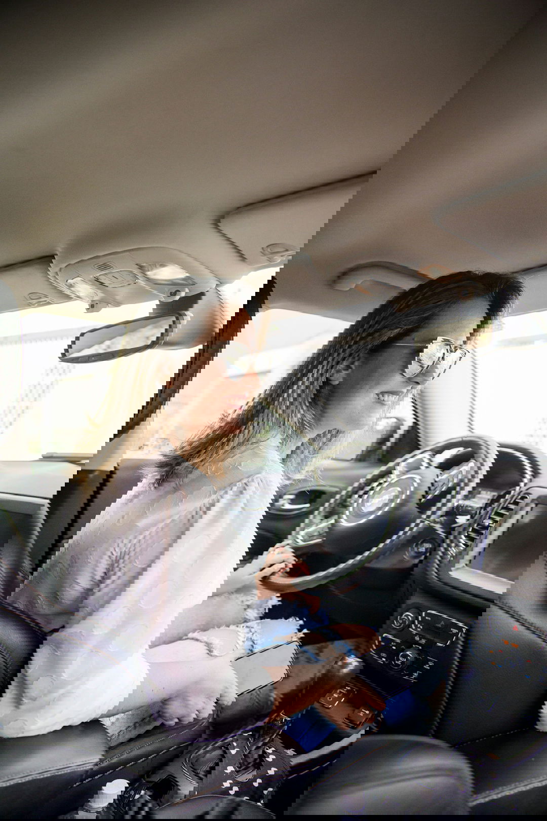 woman in white long sleeve shirt driving car