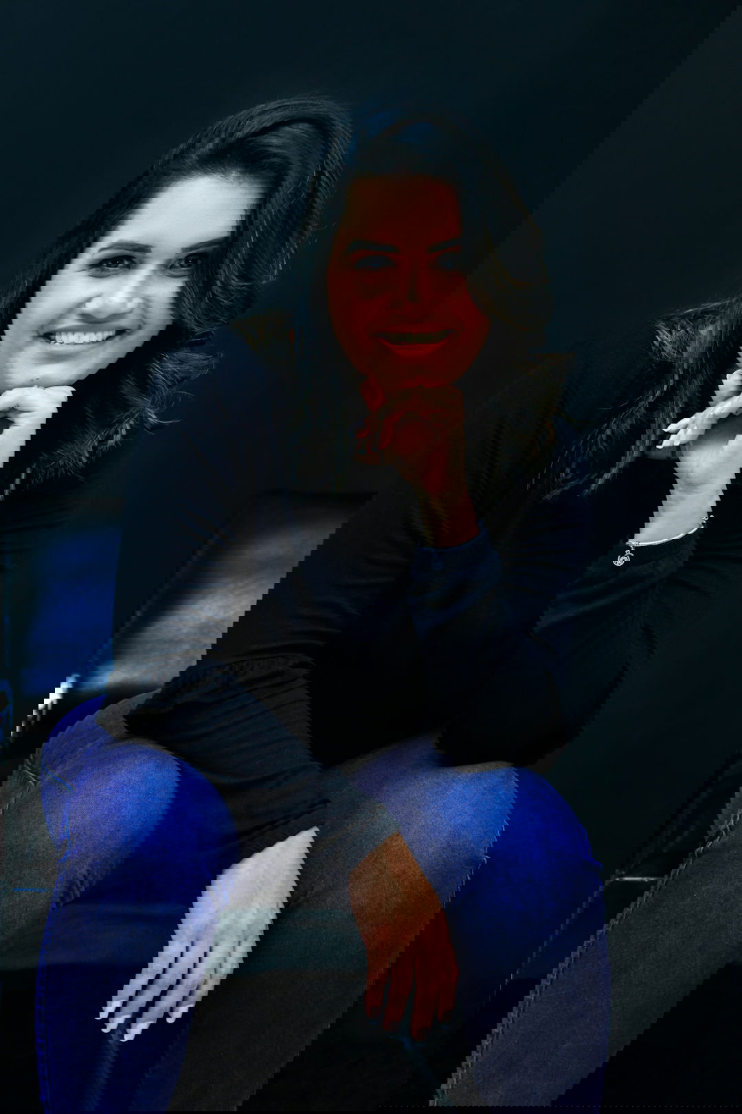 a woman sitting in a chair with her hand on her chin